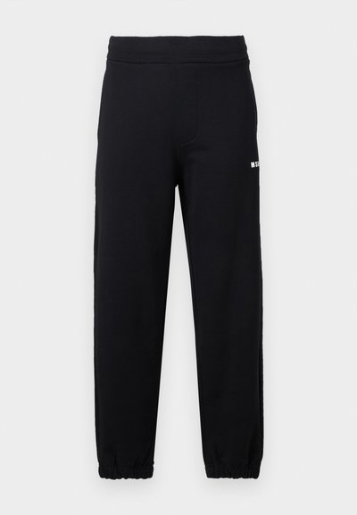 Pantalon de survêtement noir avec taille et poignets élastiques, arborant un petit logo blanc sur la partie supérieure de la cuisse gauche.