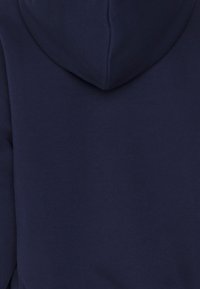 Felpa con cappuccio colore blu navy, dal tocco morbido, con un grande cappuccio e un design posteriore senza cuciture. Nessun motivo o hardware visibili.