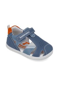 Sándalo sintético azul con correa de Velcro ajustable, diseño de punta abierta, suela blanca y acentos naranjas en el forro interior y la lengüeta del talón.