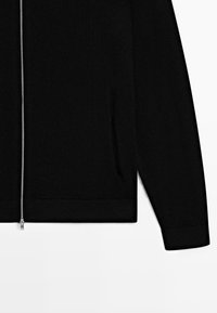 Černá mikina na zip s hladkou texturou, žebrovanými manžetami a lemem. Obsahuje stříbrný zip a boční kapsy pro užitek.