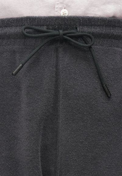 Pantalon de survêtement gris en tissu doux avec taille élastique, doté d'un cordon de serrage et d'une finition texturée.