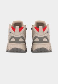 Μπεζ μποτάκια πεζοπορίας με κόκκινη εσωτερική επένδυση, γκρι σόλα και μαύρες λεπτομέρειες, σε λευκό φόντο, από πίσω άποψη.