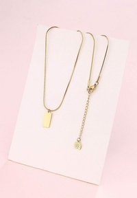 Collar en tono dorado con un colgante rectangular y una cadena con un charm de hoja. Acabado metálico suave con un diseño elegante y minimalista.