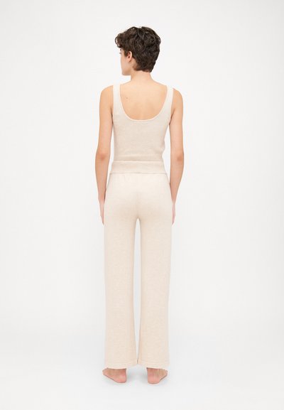 Beige tank top and matching wide-leg pants made of soft, textured fabric. Features a scoop back and an elastic waistband.