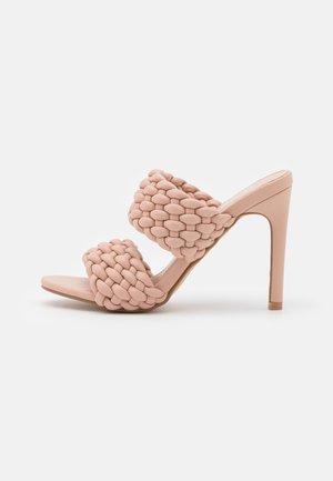 Sandales à talons hauts roses avec des brides tressées et texturées et un design ouvert à l'avant. Présente un talon fin et un dos fermé.