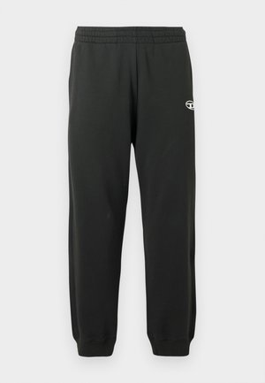 Calças de moletom pretas feitas de um tecido macio e elástico, com cintura elástica e punhos canelados. Apresenta um pequeno logo na coxa.