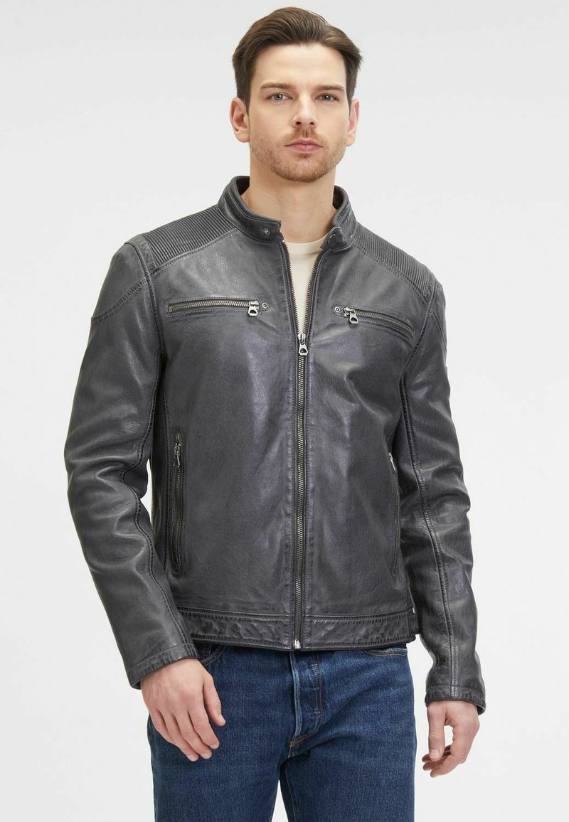 Giacca in pelle grigia con zip frontale, dettagli sulle spalle e due tasche sul petto. Texture liscia con dettagli a costine sulle spalle.