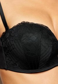 Černá krajková push-up podprsenka s květinovým vzorem, hladkým materiálem a žebrovanými detaily podél okrajů a stran. Součástí jsou nastavitelné ramínka.