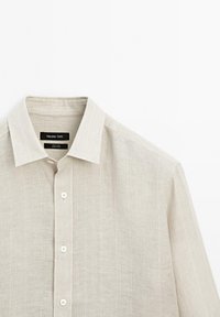 Beige long-sleeve linen shirt with collar and white buttons, featuring subtle vertical stripes and a Massimo Dutti label inside the collar.