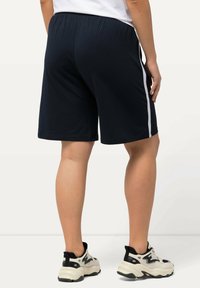 Pantaloni sportivi blu navy con una texture liscia, caratterizzati da strisce bianche sui lati. Vita elastica e vestibilità ampia per il massimo comfort.