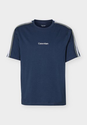 Tumesinine lühikeste varrukatega t-särk, millel on valged ja kollased triibud õlgadel ning keskel rinnal "Calvin Klein" logo.