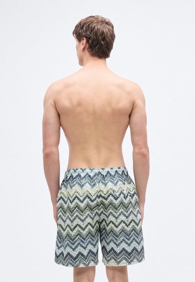 Πολύχρωμα μαγιό σε σορτς με ζιγκ-ζαγκ μοτίβο σε μπλε, πράσινο και κίτρινο. Κατασκευασμένα από ελαφρύ υλικό με ελαστική μέση.