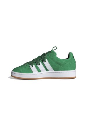Zapatilla baja de ante verde con rayas blancas y suela gruesa blanca, con cordones anchos verdes con patrón y una lengüeta con tira para tirar.