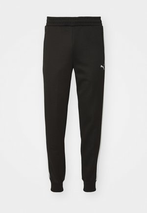 Fekete sportos nadrág, szűkített szabással, gumis derékkal, oldalsó zsebekkel és fehér oldalcsíkkal. A bal combján egy kis logó található.