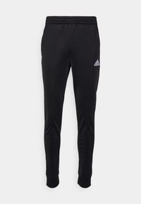 Jogging slim noir Adidas avec taille élastique et poignets aux chevilles, avec un logo Adidas blanc sur la partie supérieure de la cuisse gauche.