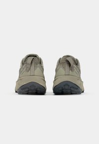 Chaussures de randonnée grises avec un dessus texturé, une languette au talon, une semelle en caoutchouc robuste et des nuances de gris variées.