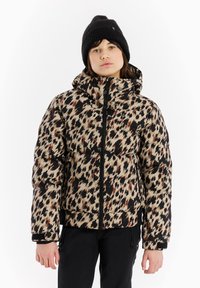 Wattierte Jacke in einem Tan-, Braun- und Schwarz-Leopardenmuster mit hohem Kragen, Frontreißverschluss und elastischen Bündchen. Getragen mit einer schwarzen Strickmütze.