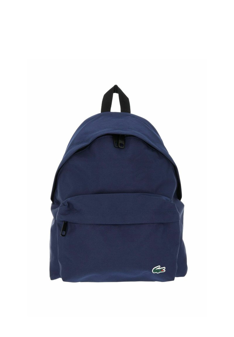 Navy blue backpack with front zip pocket, black handle on top, and small green crocodile logo on the lower right corner.