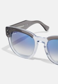 Ray-Ban'i prillid selge ja halli gradientraamiga, millel on sinine gradientprillide lääts ja metallaktsentid. Ruutjas kuju julge disainiga.
