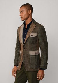Bruin en groen geruit blazer met contrasterende beige accenten, twee voorkanten zakken en een getailleerde pasvorm, gemaakt van textuurstof.