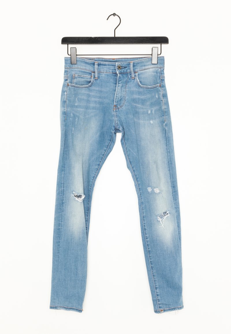 Ljust blå slitna jeans med en åtsittande design, lätt blekning och framträdande hål vid knäna. Tillverkade av bomullsdenim.
