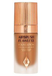 Airbrush Flawless Foundation bottle features a frosted gradient design, gold accents, and a ribbed gold cap. Text includes product name and claims.