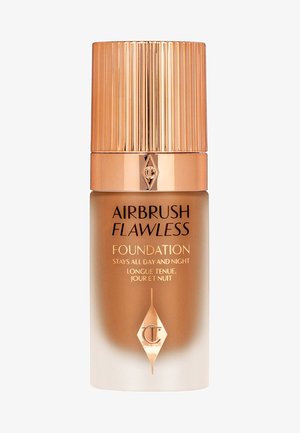 Die Flasche des Airbrush Flawless Foundation hat ein frosted Gradient-Design, goldene Akzente und einen gerippten Goldverschluss. Der Text umfasst den Produktnamen und die Versprechungen.