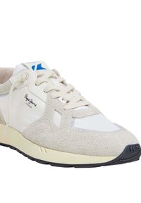 Zapatillas con parte superior de ante crema y sintético blanco, diseño con cordones, acento azul en la lengüeta y suela de goma negra.