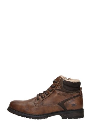 Bruine leren enkelboots met een zachte bontvoering, metalen oogjes en contrasterende donkerbruine accenten. Voorzien van een stevige rubberen zool.