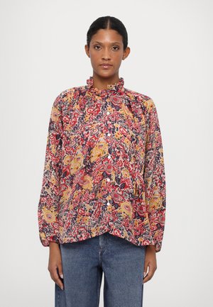 Blomstrete bluse med volangkrage, lange ermer og knappelukking. Fargene inkluderer rød, gul og marineblå på en kremfarget bakgrunn.