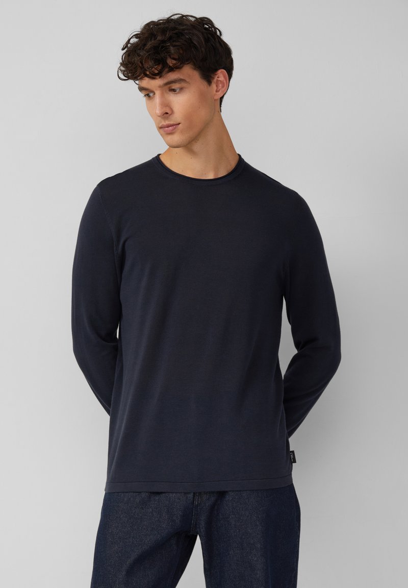 Marineblauwe longsleeve t-shirt van zacht materiaal, met een ronde hals en een relaxte pasvorm. Heeft subtiele stikdetails en een klein logo-label aan de zoom.
