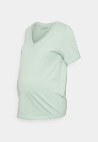 T-shirt de maternidade em verde menta claro com decote em V, mangas curtas e um corte descontraído. Feito de tecido de algodão suave com uma textura lisa.