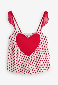 Top s bodkami s červenou aplikáciou v tvare srdca. Biela látka s červenými bodkami, volánikové ramienka a voľný, rozšírený strih. Ležérny a hravý štýl.
