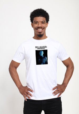 Hvid bomulds t-shirt med et trykt grafisk motiv af en karakter fra "Hellraiser: Inferno" i blå nuancer med sorte detaljer.