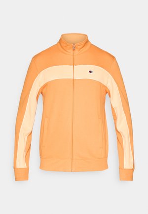 Orangefarbene Jacke mit Reißverschluss und hohem Kragen, mit einem helleren orangen Streifen über der Brust und zwei Seitentaschen. Glatte Textur, sportliches Design.