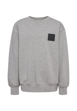 To børn stående side om side iført matchende grå sweatshirts og joggingbukser med sorte logoer, neutrale ansigtsudtryk, ensfarvet baggrund.