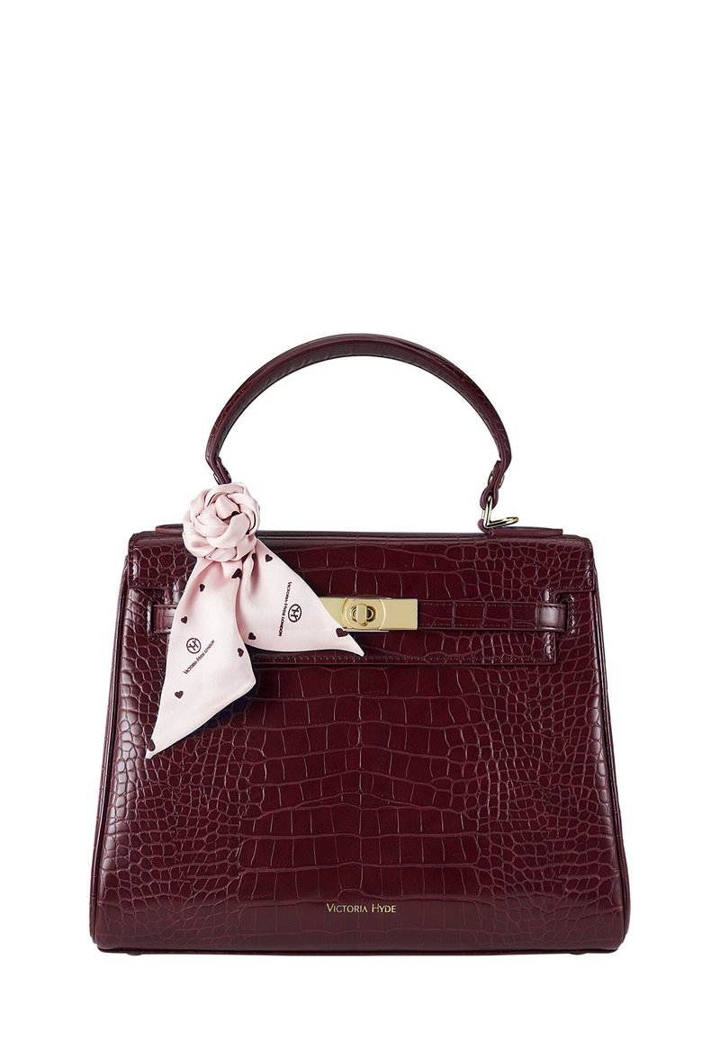 Maroon krokodille-embossed läderhandväska med en strukturerad form, topphandtag, gyllene detaljer och en rosa scarf accent som är knuten vid handtaget.