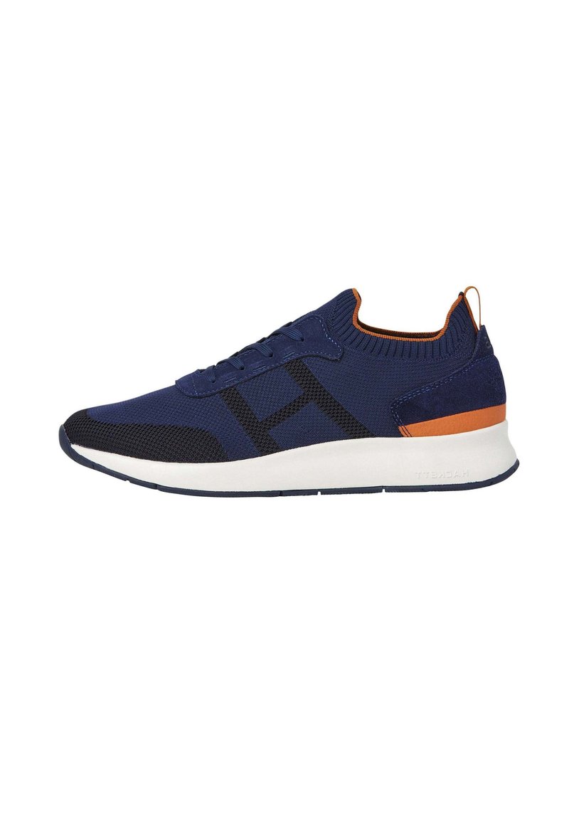 Zapatos deportivos azul marino con parte superior de punto, detalle de malla negra, acentos naranjas y una suela blanca acolchada. Presentan un diseño de cordones.