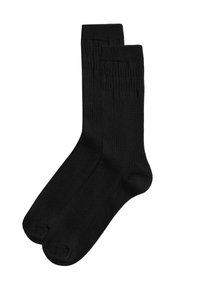 Calzini alla caviglia neri realizzati in un tessuto morbido ed elastico. Presentano una texture a coste sulla parte superiore e una finitura liscia su tutta la superficie.