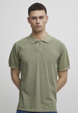 Grønn bomulls polo skjorte med klassisk krage, to-knappslukking og korte ermer. Har en subtil logo på venstre bryst.