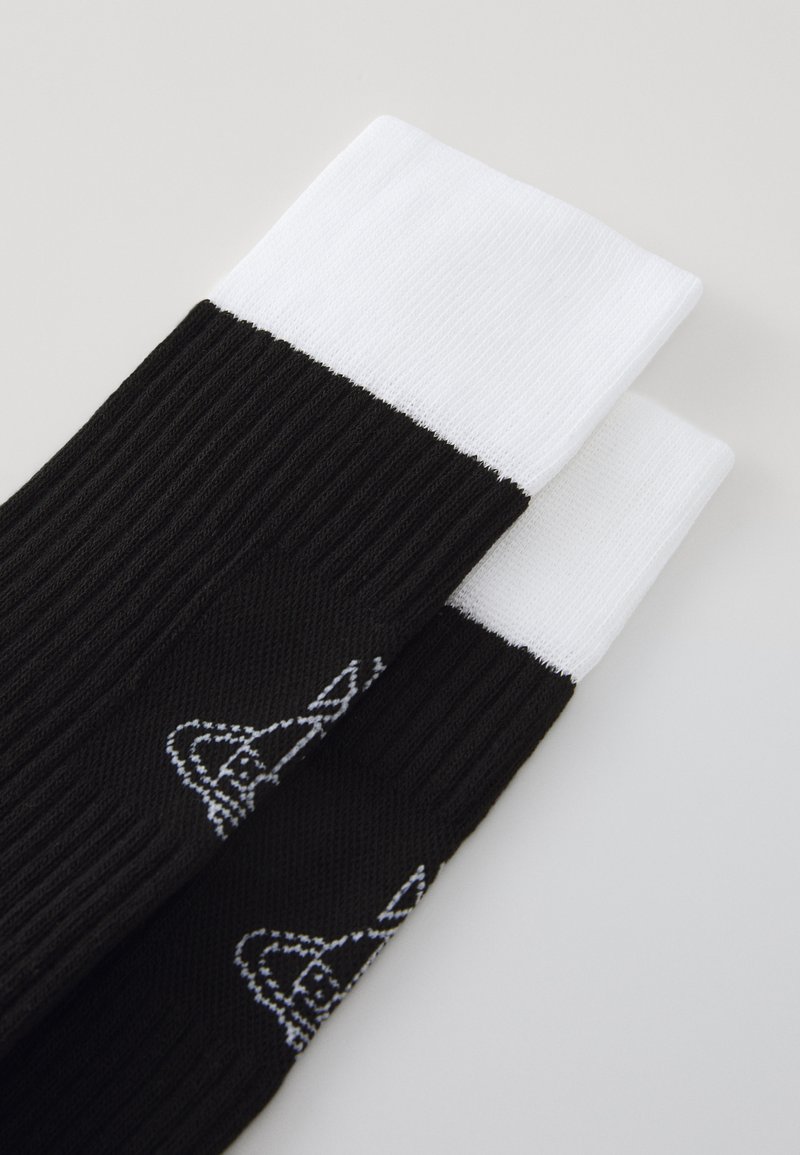 Zwarte geribde sokken met een witte manchette, met een subtiele grafische ontwerp in het wit. Het materiaal lijkt glad en rekbaar.