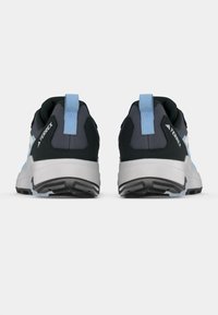 Μαύρα και ανοιχτό μπλε αθλητικά παπούτσια με υφή στην επιφάνεια, δύο δακτυλίδια έλξης και επενδεδυμένη λευκή σόλα. Η πίσω όψη αναδεικνύει το λογότυπο.
