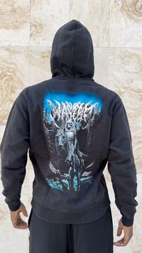 Melnā kapucēta džemperis ar grafiku, kurā attēlots skeletu tēls kopā ar zirgu, detalizēts zilā un zaļā krāsā uz tumša fona.