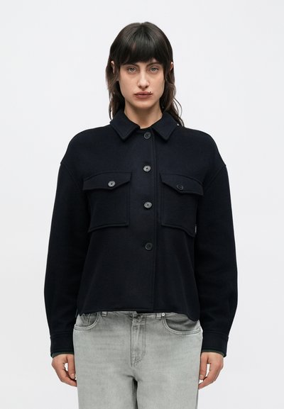 Veste-chemise noire en mélange de laine avec col, cinq boutons et deux poches à rabat sur le devant. Coupe décontractée avec une texture lisse.