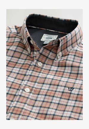Camisa de cuadros abotonada en beige, marino y rojo. Tela de algodón, con un cuello clásico, botones blancos y un pequeño logo bordado en el pecho.
