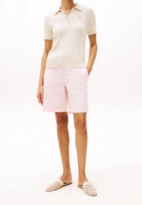 Cremfarbene Kabelstrick-Polohemd, hellrosa Shorts und beigen gewebten Schn slip-on Schuhen. Mit kurzen Ärmeln und einem Kragen.