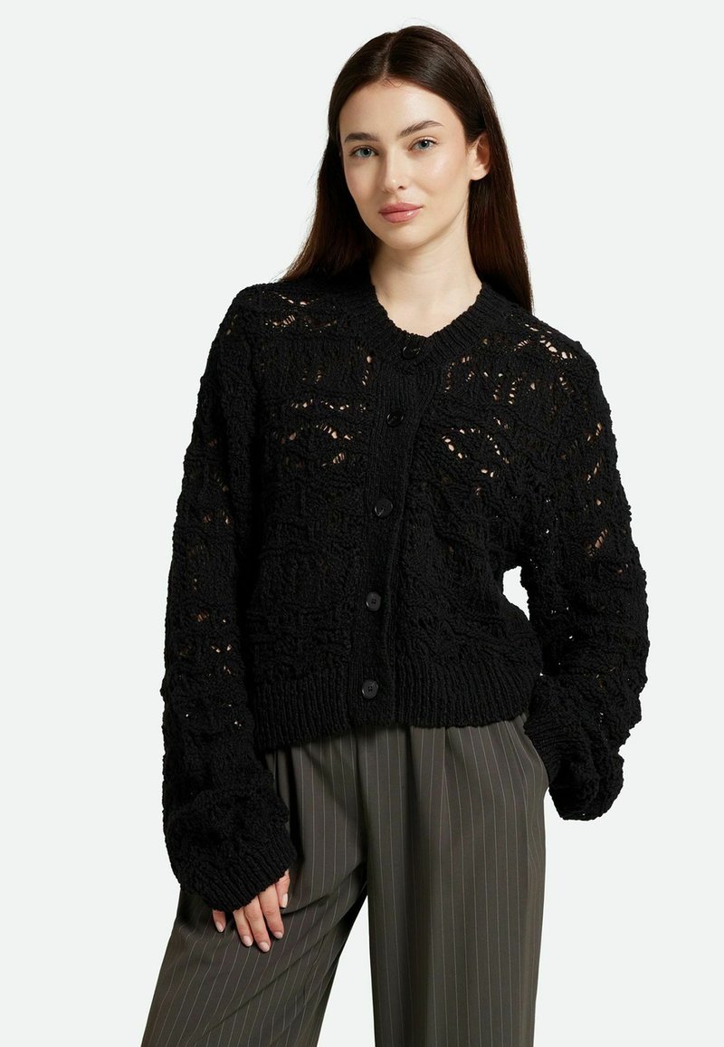 Cardigan noir en tricot avec un motif texturé, doté d'un col rond, de manches longues et d'une fermeture à boutons à l'avant.