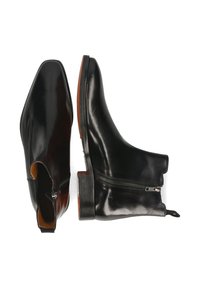 Schwarze Lederstiefeletten mit quadratischer Spitze, seitlichem Reißverschluss und brauner Sohle. Glatte Textur, minimales Design und flacher Absatz.