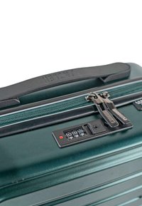 Maleta rígida verde con una superficie texturizada, cremalleras dobles y una cerradura de combinación. Cuenta con un asa de goma negra en la parte superior.