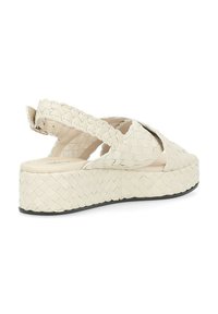 Sandali platform beige intrecciati con design slingback, dotati di una tomaia testurizzata e di una suola nera solida. Tra i dettagli ci sono cinturini incrociati.
